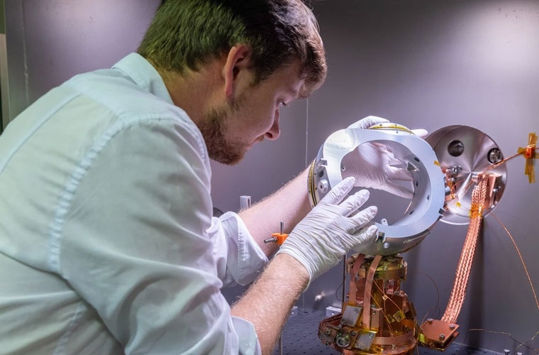 IPP-Wissenschaftler Paul Huslage montiert eine Modellspule im Teststand. Darin lassen sich Magnetspulen bei Temperaturen von 20 Kelvin (-253 Grad Celsius) unter Vakuumbedingungen untersuchen.