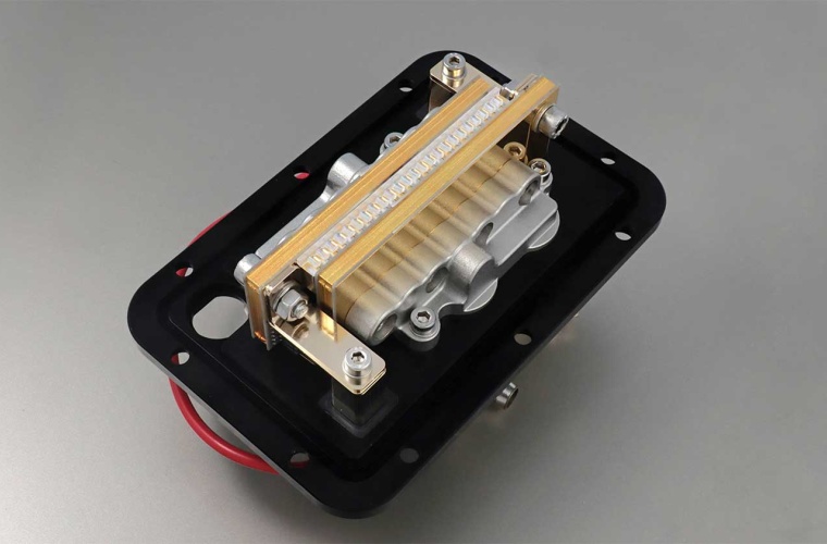 High-Power Dioden-Laserstack
Ein mechanisches Bauteil auf einem schwarzen Grund, mit einem silbernen Gehäuse und einer goldenen Leiste. Das Teil enthält verschiedene bewegliche Elemente und Anschlüsse.

FBH/P. Immerz