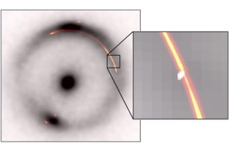 Der schwarze Ring und der zentrale Punkt zeigen das durch eine Gravitationslinse verzerrte Infrarotbild einer entfernten Galaxie. Orange/reg zeigt Radiowellen von demselben Objekt. Der Einschub zeigt eine Verengung durch eine andere, viel kleinere, dunkle Gravitationslinse (weißer Fleck).