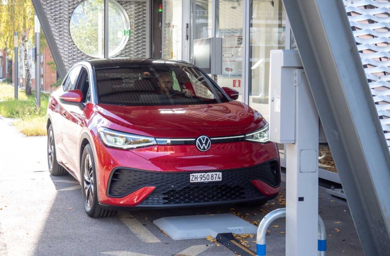Ein umgerüstetes E-Auto lädt kabellos über die im Boden integrierte Spule – der Ladevorgang startet automatisch, sobald das Fahrzeug korrekt parkiert ist. Bild: Empa