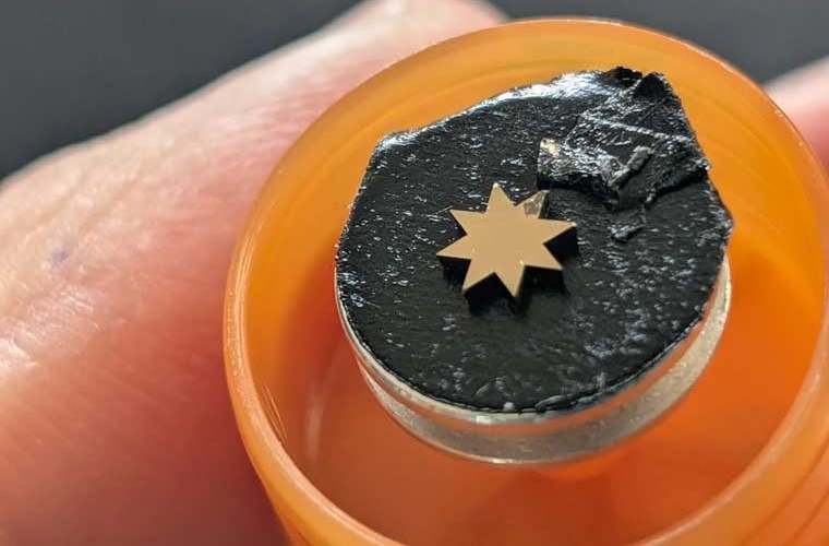 Für die Her­stel­lung der Krip­pe wurde eine Dia­mant­probe mit einem Schneid­laser stern­förmig zuge­schnit­ten und anschließend mit einer wenige Nano­meter dicken Lage Gold be­dampft. In diese Gold-Lage wurde mit Hil­fe eines fokus­sierten Ionen­strahls an einem focus­sed ion beam Gerät (FIB) die Krip­pe in einer Größe von 5 × 5 Mikro­metern ge­schnit­ten. Univer­sität Augs­burg