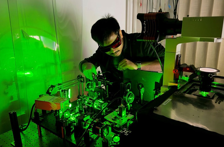 Diptabrata Paul bei der Justage des experimentellen Aufbaus, in dem Maschinenlernen und Mikroschwimmer in Flüssigkeitsströmungen gekoppelt werden.