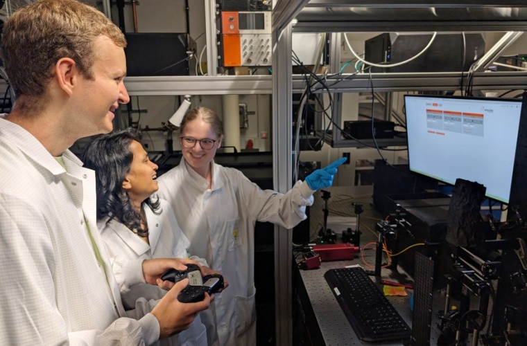 Der Doktorand Anton Loegl (vorn), die Doktorandin Priyanka Mondal (Mitte) und die Master-Studentin Alison Pfister, AG Hybride Quantensysteme, untersuchen die optischen Eigenschaften von 2D-Halbleitern mit einer Dicke von nur einem Nanometer, in denen Informationen mit Lasern geschrieben und ausgelesen werden können.