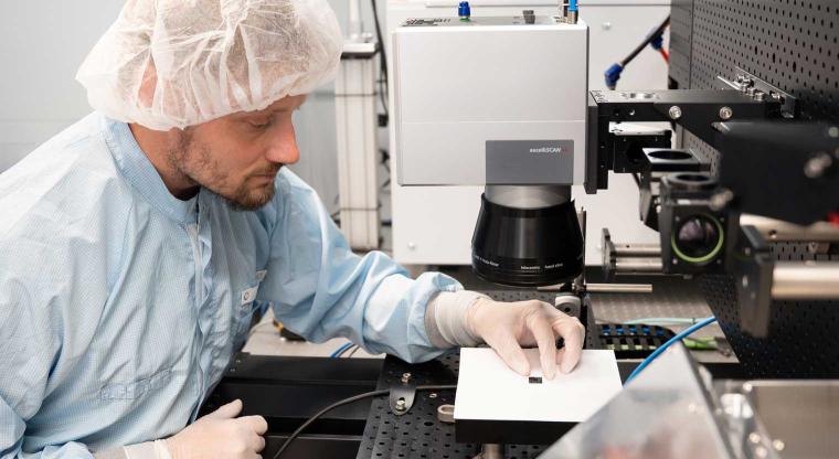 Ein Mitarbeiter prüft die Qualität der Kühlstrukturen des Mikrochips....