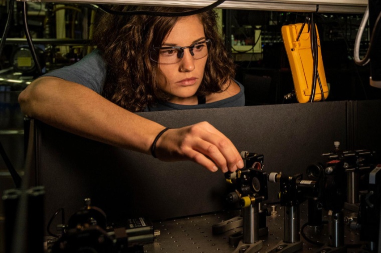 Abb.: Katie McCormick justiert einen Laser­strahl, mit dem ein Beryl­lium-Ion...