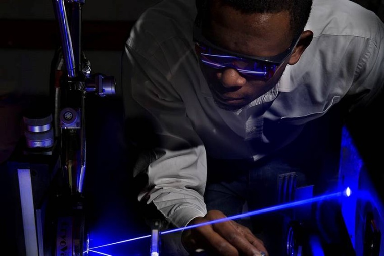 Abb.: Hilary Masenda führt im Labor von Martin Koch Laser­experi­mente an...