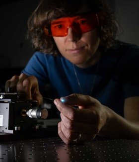 Andrea Toulouse koppelt Licht eines Lasers in eine optische Faser, deren leuchtende Spitze zu einem Mini-3D-Drucker werden soll.