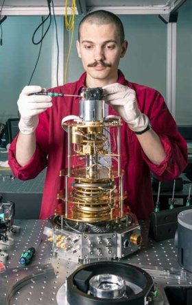 Ein KIT-Mitarbeiter integriert einen optischen Quantenspeicher in einen Kryostaten und koppelt ihn optisch per Glasfaser an ein supraleitendes Qubit. (Foto: Markus Breig, KIT)