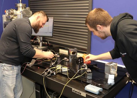 Die Studenten Viljon Sekseni (l.) und Kersten Mumme (Engineering Physics, 5. Semester), berei-ten derzeit die Mess-Station im Hochschullabor vor. Mit dieser soll der Laserfrequenzkamm geprüft und anschließend für die Kalibrierung genutzt werden