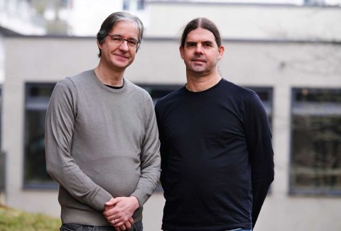 Der Physiker Peter P. Orth (links) und der Informatiker Markus Bläser erforschen im gemeinsamen Projekt QIAPO mit den Industriepartnern Infineon und BMW sowie dem Quanten-Start-up planqc, wie sich die Vorteile von klassischen Rechnern und Quantencomputern zusammenführen lassen.