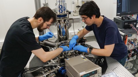 David Walther (l.) und Carlos Rincon, Wissenschaftliche Mitarbeiter der Professur Werkstoffe und Zuverlässigkeit mikrotechnischer Systeme der TU Chemnitz, installieren einen neuen Teststand in der Kammer eines Helium-Kryostaten. Er ermöglicht die Bestimmung thermischer Eigenschaften dünner Schichten bei Temperaturen zwischen -269 °C und +25 °C. Foto: Dr. Uwe Zschenderlein