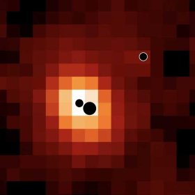 Karte der weit entfernten Galaxie J0148-4214 in ionisiertem Wasserstoff (Hα). Die Positionen der drei massereichen Schwarzen Löcher sind durch schwarze Kreise gekennzeichnet (nicht maßstabsgetreu). Das massereichste und das am wenigsten massereiche Schwarze Loch befinden sich im Zentrum der Galaxie; ein drittes Schwarzes Loch befindet sich am Rand der Galaxie.
© Hannah Übler